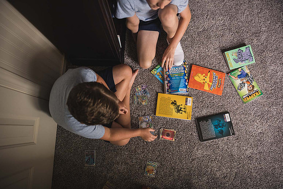 brothers playing with pokemon on the floor of one of their rooms