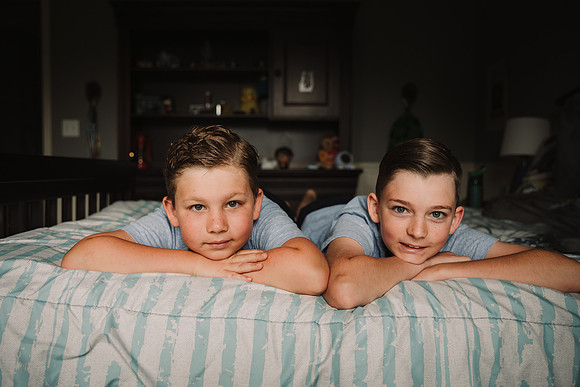portrait of two boys laying on a bed by monica carlson photography