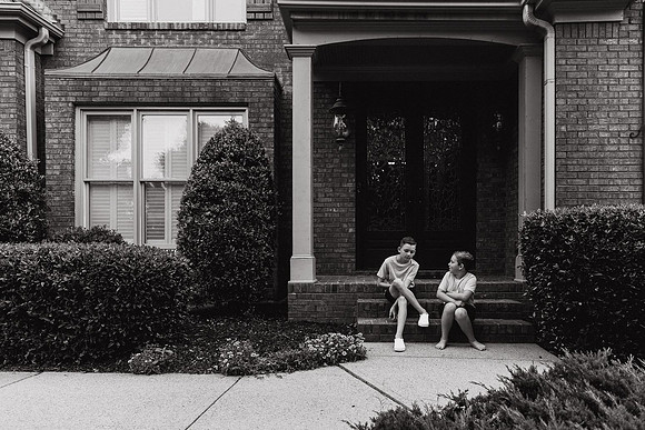 two brothers chatting on the steps of their house