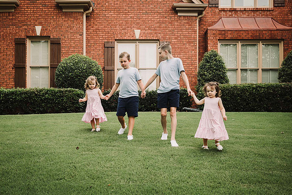 four siblings walking in front of their house by monica carlson