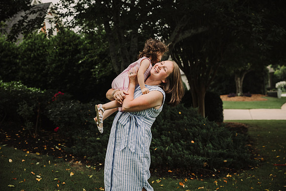 mother happily lifting her daughter in the air