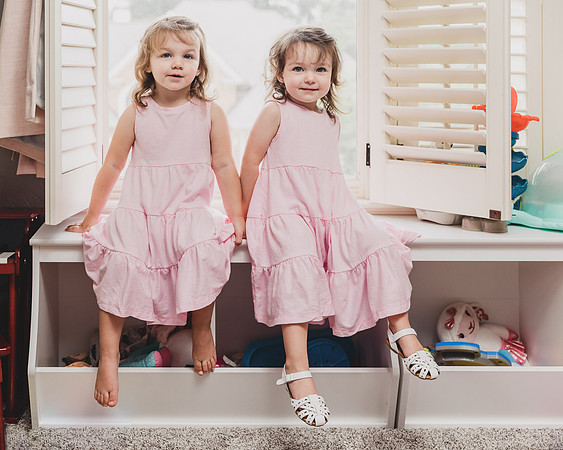 two little girls sitting on the furniture in their room by monica carlson
