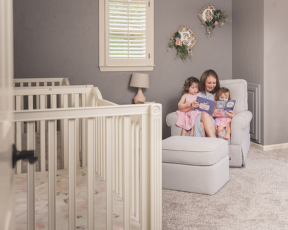 view looking into the room of twins who are reading a book with their mother