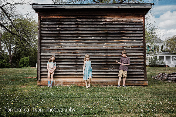 three siblings standing in front of the smoke house at Barrington Hall