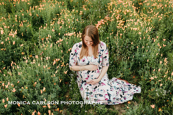 mother sits in a field while holding her pregnant belly in lawernceville