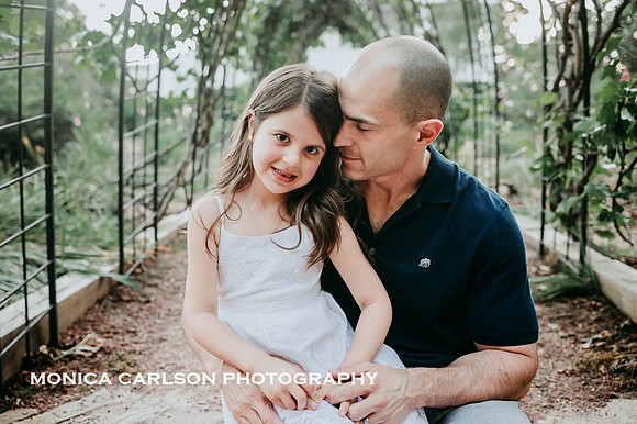 father and daughter lovingly sit together in a garden