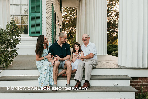 family sitting together on the porch of a historic home in Roswell, GA