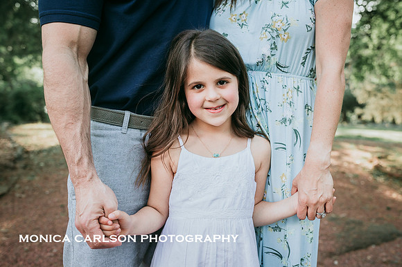 little girl holding her parents hands