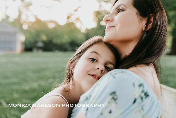 little girl snuggling her mother outside Barrington hall