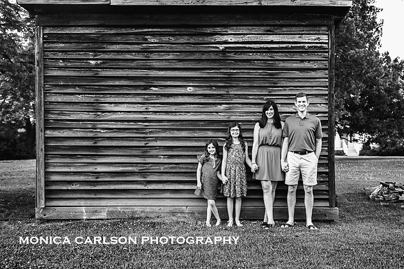 family of four standing together in front a wooden building in Roswell by monica carlson