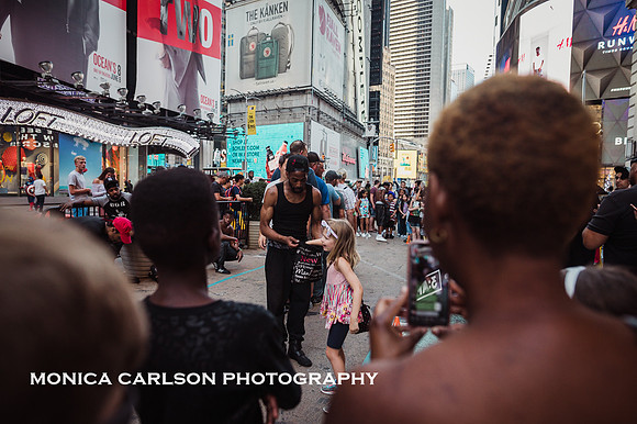 little girl paying a street performer in times square