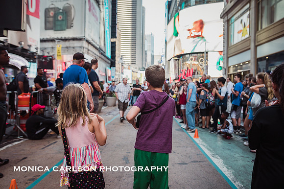 two kids looking down a street in times square
