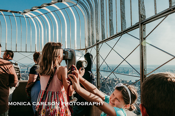 tween girl taking a selfie of her self on the observation deck of the empire state building