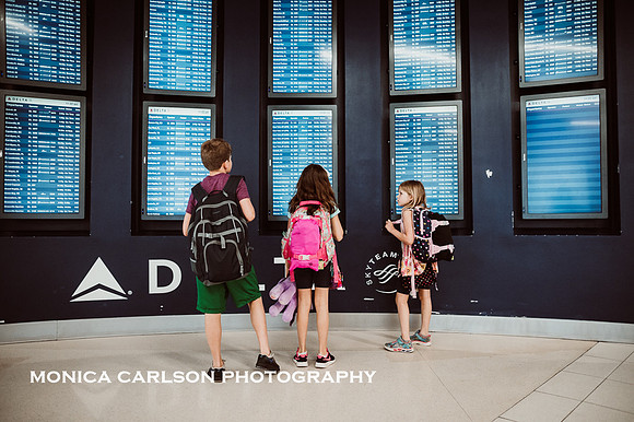 three kids looking at flights in Atlanta's Hartsfield-Jackson Airport