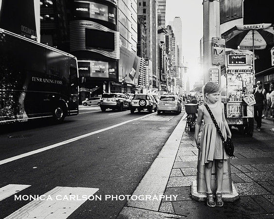 girl pouting and leaning against a light pole in Times Square