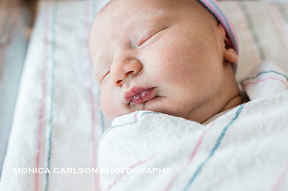 portrait of a chubby cheeked newborn in his hospital cap and blanket