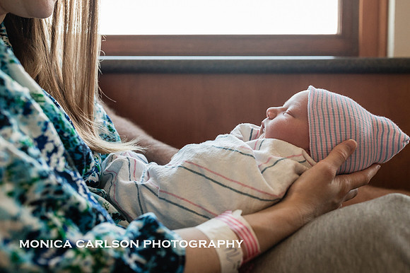 profile photo of a newborn in his hospital outfit while his mother holds him in her lap