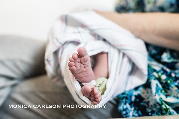 close up of a newborns tiny feet and hospital band