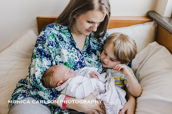 mother gently introduces new baby to his toddler brother during a fresh 48 photo session at Northside Hospital