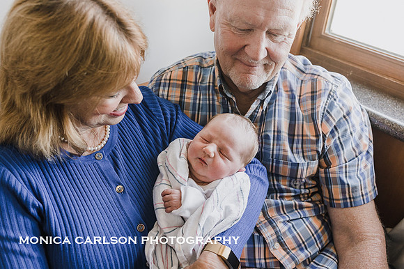 freshly born baby sleeps peacefully in grandparents arms