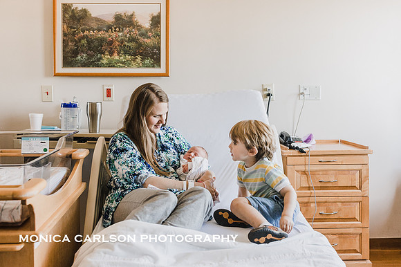 mother lays in hospital bed with both her sons and listens to what the older one has to say