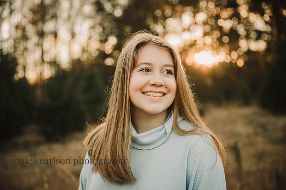 portrait of a happy teen girl at sunset by monica carlson