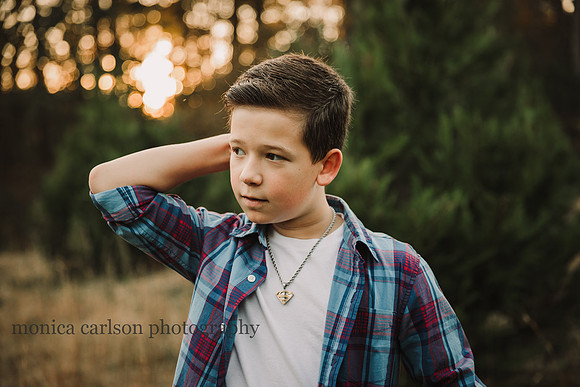 teen boy scratches his head while looking away