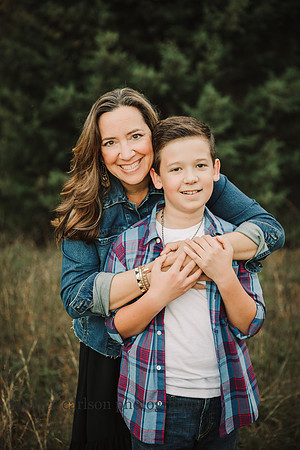 mother smiles while hugging her teen son