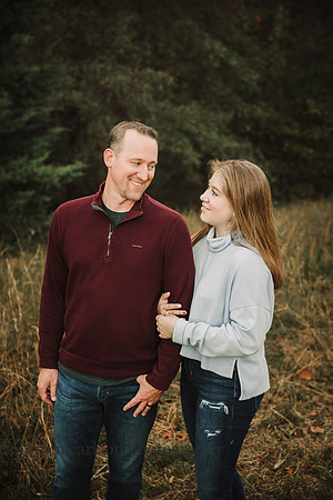 father looks at his teen daughter knowingly during a family photo session