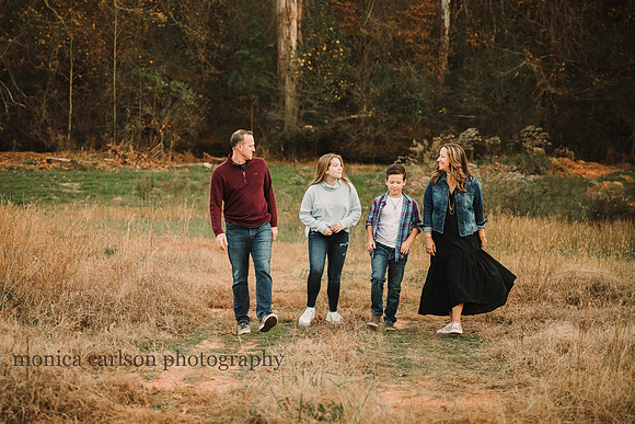 family of four walk along a dirt trail at hunter's family farm