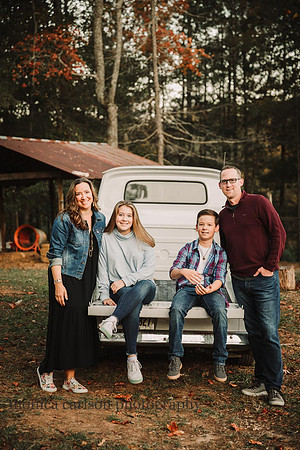 mother, father, son and daughter sit in the bed of a vintage truck in Milton, ga