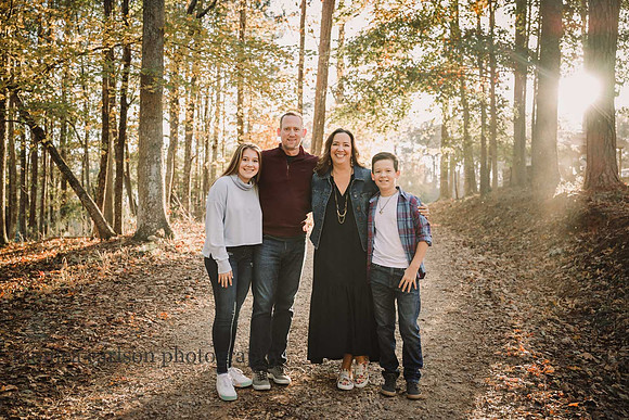 family of four on a trail at Hunters Christmas tree farm at sunset