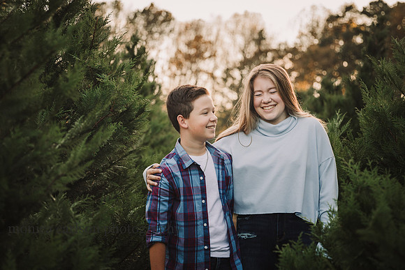 teen siblings laugh together during afamily photo session at Hunter's family farm