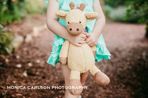 tiny girl's hands clutching a stuffed giraffe