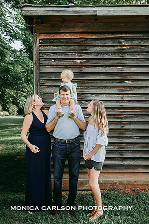 family of four standing in front of a wooden building in historic Roswell by Monica carlson