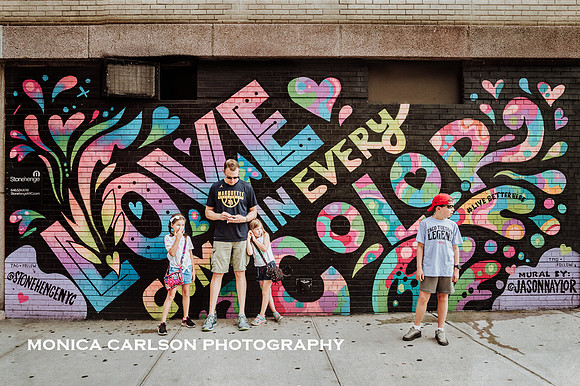 man and three children stand in front of street art on the east side of Manhattan