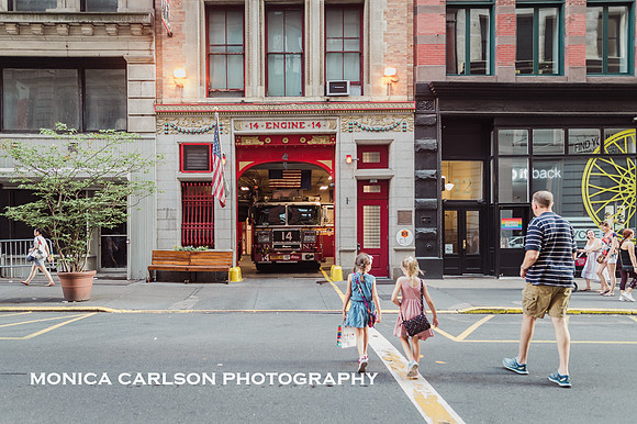 man crosses new york city street to visit a firehouse with children