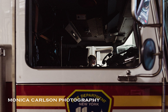 girl sits in a new york city fire truck