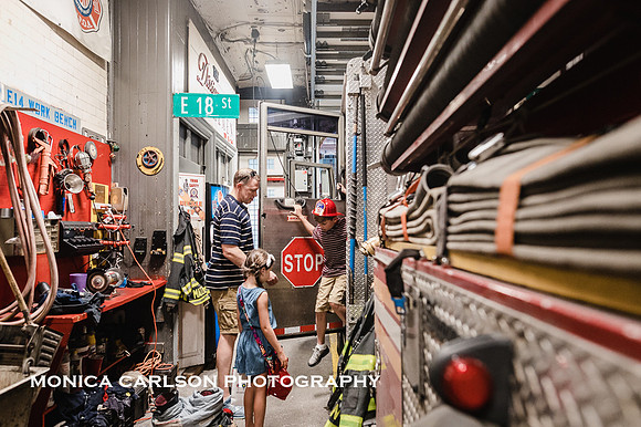 father helps son out of a new york city fire truck during a tour of the station