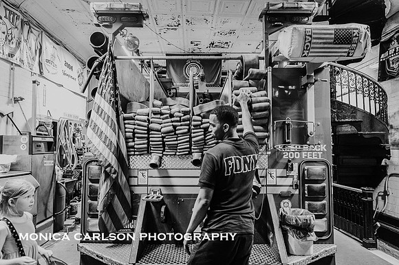 New York city Fire man talks to a girl about the firehouse on the fire truck