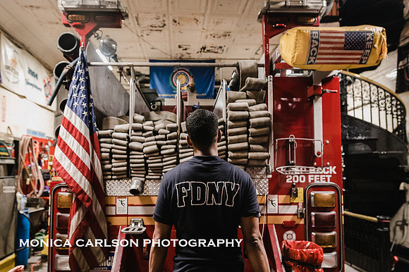 Fireman for new york city fire department stands in front of a fire truck