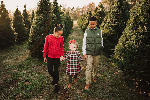three siblings dressed for holidays walking around Bottoms Tree farm