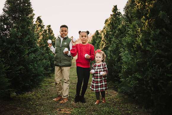 three young siblings prepare to throw pretend snow balls at the camera