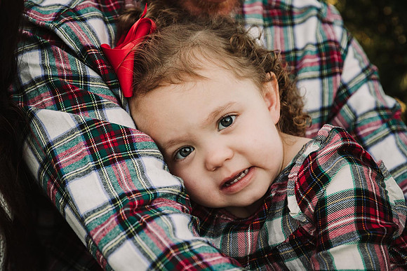 portrait of a little in a holiday outfit snuggling with her father