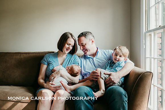 Portrait of a new family of four on a couch in their home outside Atlanta by Monica carlson