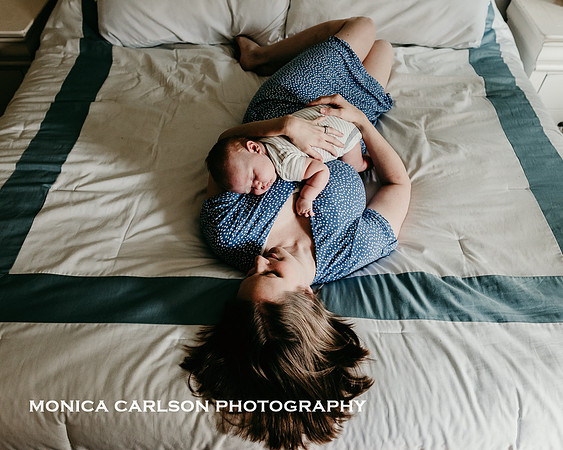 Glowing new mother laying on her bed with her baby on her chest