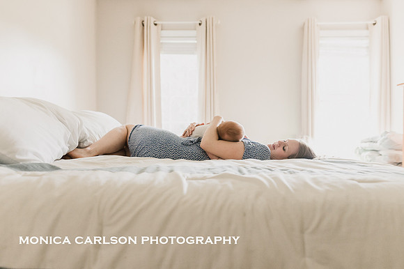 Backlight image of a mother laying on her bed by Monica Carlson