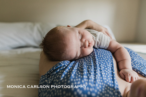 Sleepy baby laying on her mother at home in Marietta