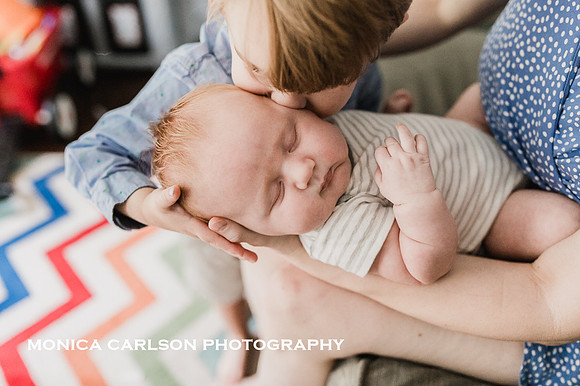 Big brother kissing his new brother at home in Marietta