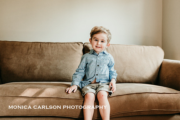 Cute little boy with messy hair sitting on a couch at home in Georgia